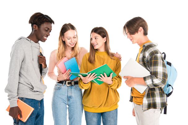 Smiling multicultural teenagers with laptop, books and backpacks isolated on white - Фото, зображення