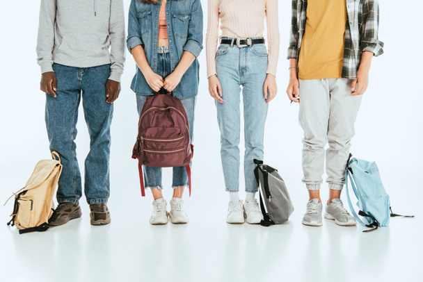 Vista recortada de adolescentes multiétnicos con mochilas sobre fondo gris - Foto, Imagen