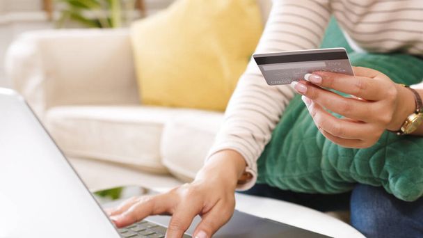 Close-up vrouw hand met behulp van computer laptop en creditcard om betaling en online winkelen te maken - Foto, afbeelding