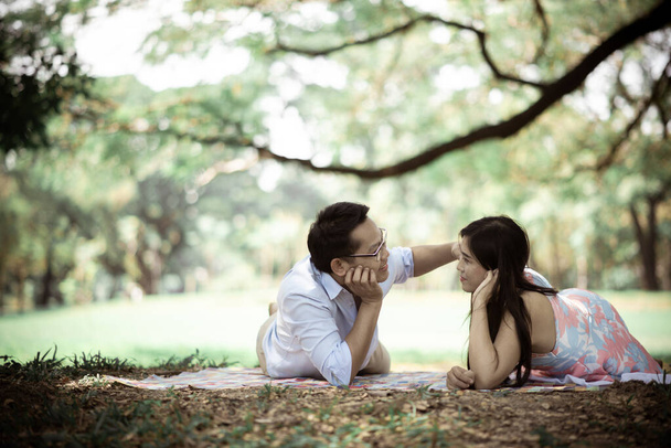 Ρομαντικό ζευγάρι που βρίσκεται στο γήπεδο στο πάρκο - Φωτογραφία, εικόνα