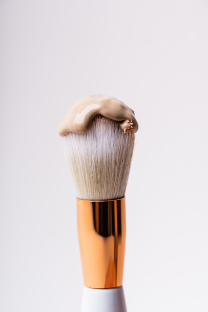 close up view of cosmetic brush with face foundation isolated on white - Photo, Image