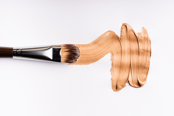 top view of cosmetic brush with face foundation brushstrokes isolated on white - Fotografie, Obrázek