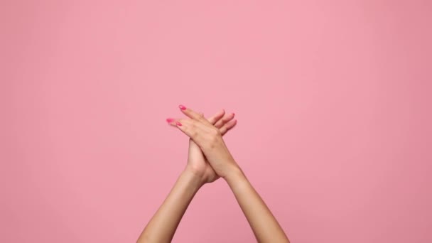 Frau hält Hände in die Luft und klatscht, feiert und gratuliert auf rosa Hintergrund - Filmmaterial, Video