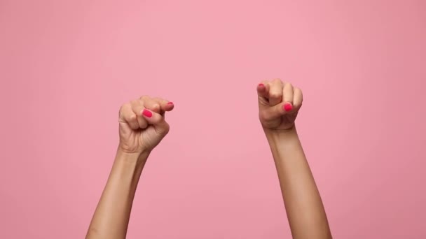 vrouw handen wijzen vingers, het maken van duimen omhoog gebaar en vieren overwinning op roze achtergrond - Video