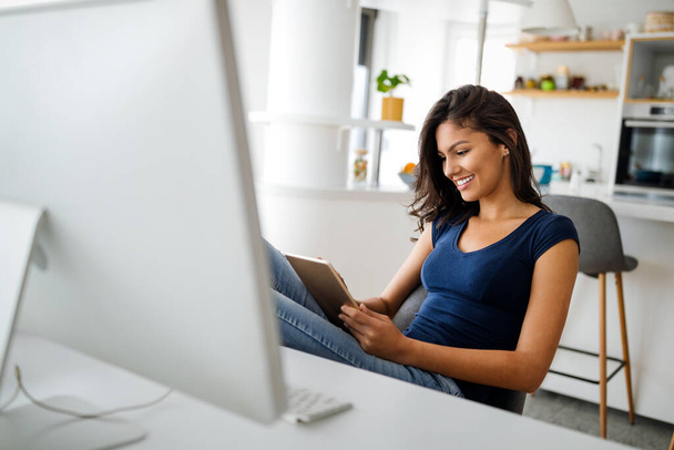 Beautiful businesswoman entrepreneur working on laptop from home office - 写真・画像