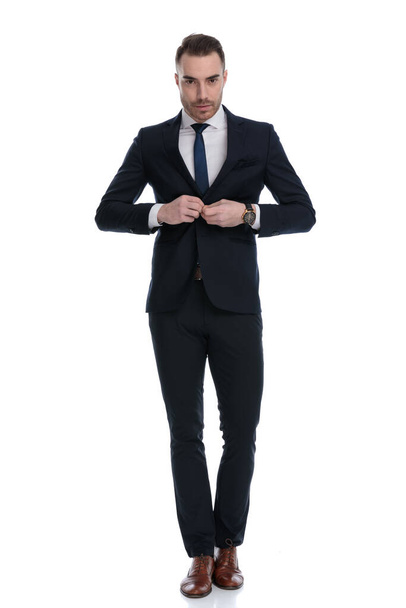 Αυτοπεποίθηση επιχειρηματίας ξεκούμπωμα σακάκι, ενώ το πάτημα σε λευκό φόντο στούντιο - Φωτογραφία, εικόνα
