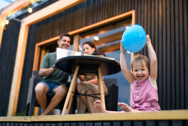 Young family with small daughter outdoors, weekend away in container house in countryside. - 写真・画像