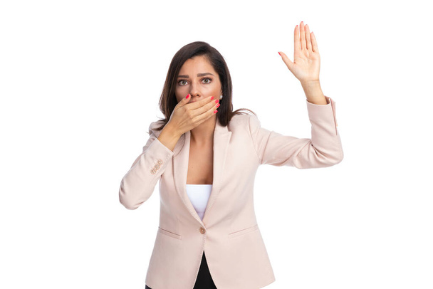 Занепокоєна бізнес-леді, яка піднімає руку і прикриває рот, стоячи на білому фоні студії
 - Фото, зображення
