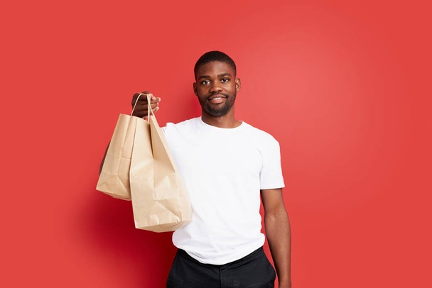 young african courier man hold paper bags with food - Photo, Image
