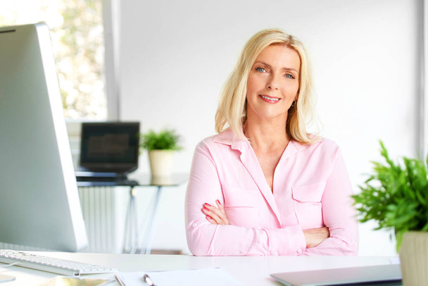 Portrait of executive businesswoman with folded arms sitting at office desk and looking at camera. - Fotoğraf, Görsel