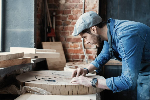 Successful handsome businessman with stylish cap work in carpentry - Fotó, kép