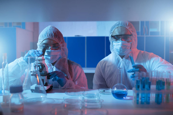 Ο γιατρός στο εργαστήριο αναλύει δείγματα κάτω από ένα μικροσκόπιο. Έννοια της φαρμακευτικής επεξεργασίας. - Φωτογραφία, εικόνα