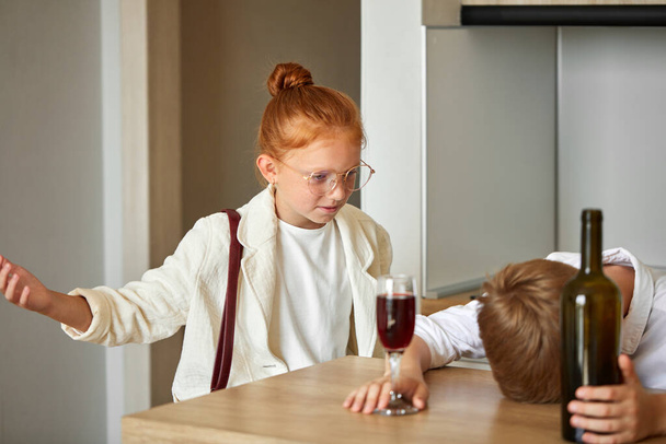 young kids couple at home, boy is drinking alcohol - Foto, Imagen