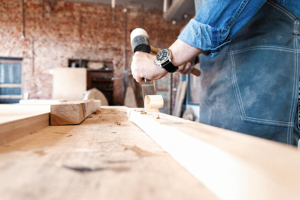 Carpenter working on woodworking machines in carpentry shop. A man works in a carpentry shop. - Foto, Imagen