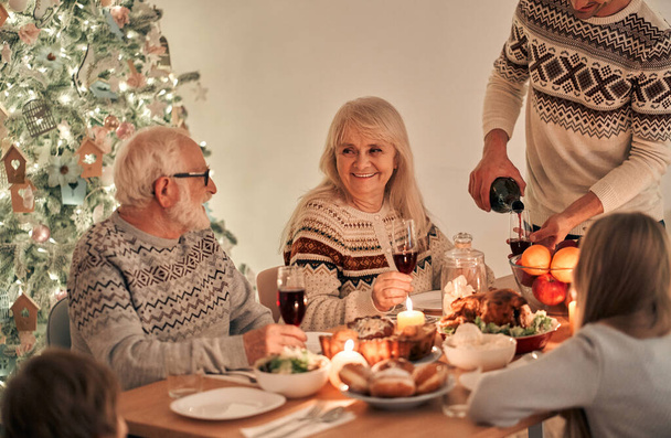 The man fills wine glasses above the festive table - Zdjęcie, obraz