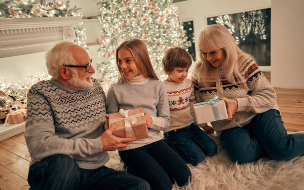 The grandparents giving gifts to children - Photo, Image
