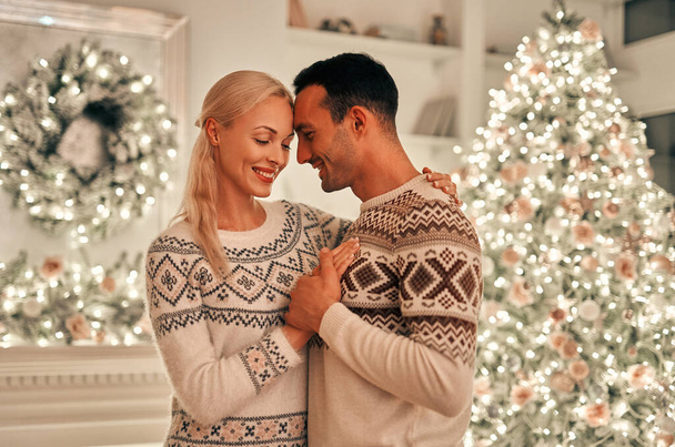 The couple standing on the christmas tree background - Φωτογραφία, εικόνα