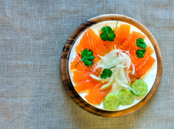 appetizer red salmon fish, lemon, cucumber slices on wooden board, top view  - Foto, Imagem