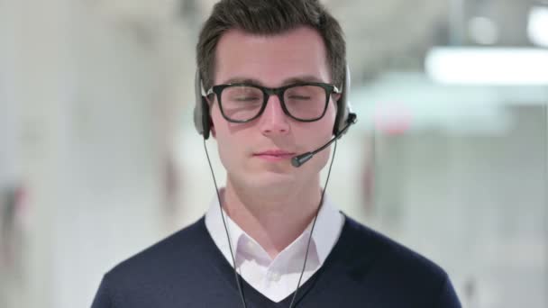 Junger Geschäftsmann mit Headset lächelt in die Kamera  - Filmmaterial, Video