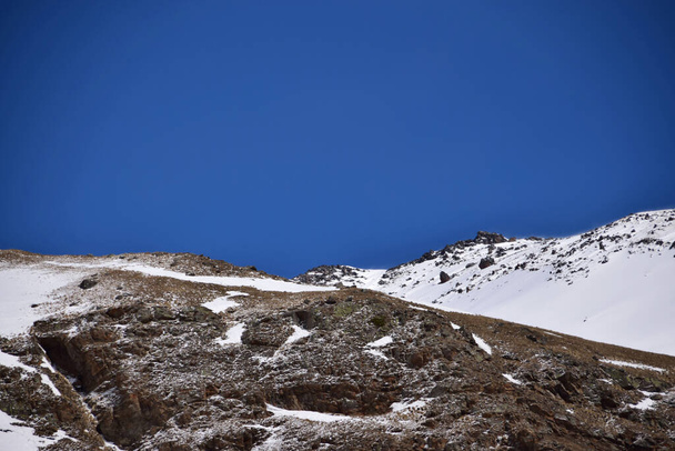  View of the snowy rocky ridge and blue sky at the foot of Mount Elbrus in the Azau Valley in the mountains of the North Caucasus                               - Valokuva, kuva