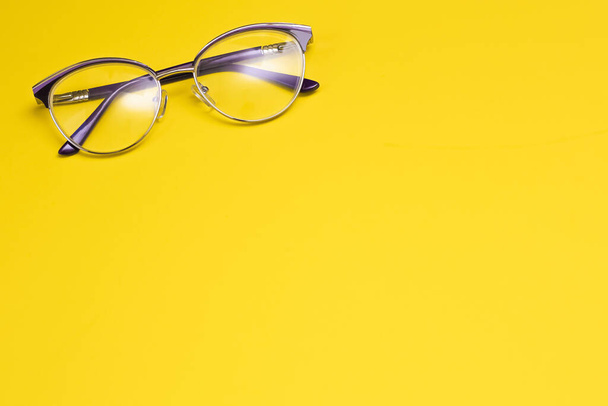 Fashionable glasses on a yellow background. Vision correction. Glasses for sight. Optics. Copy spase - Zdjęcie, obraz
