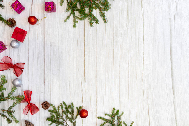Weihnachtlicher Hintergrund. Neujahr, Flatlay. Grüner Weihnachtsbaum mit festlichem Schmuck und Spielzeug auf hellem Holzgrund. Draufsicht mit Platz für Text. Frohe Weihnachten. - Foto, Bild