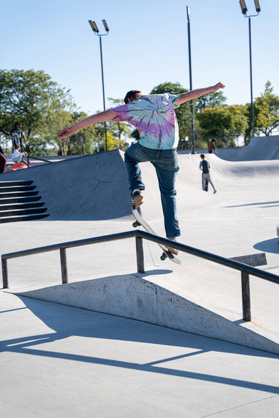 skaters at an outdoor skatepark practice tricks on a sunny afternoon in Detroit - Foto, Imagen