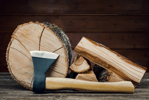 Axe and firewood, against the background of wooden boards. - Fotografie, Obrázek