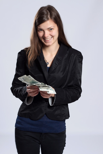 Young long-haired woman holding money - Valokuva, kuva