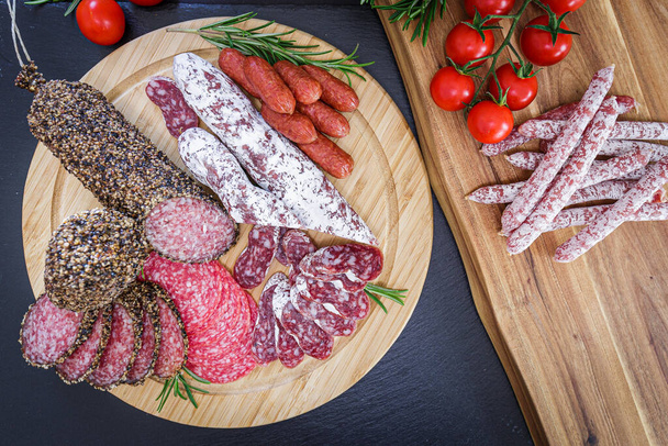 Różne krojone włoskie salami wieprzowe na drewnianym talerzu - Zdjęcie, obraz