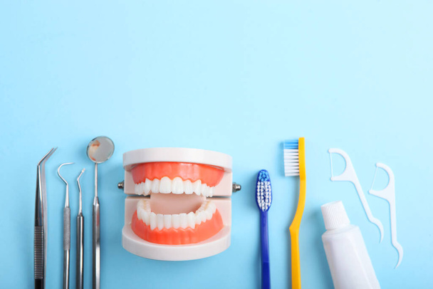 modelo de dientes e instrumentos dentales y productos de cuidado dental sobre fondo de color - Foto, imagen