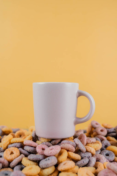 A vertical shot of a colorful cereal heap with a coffee cup on top - Photo, Image