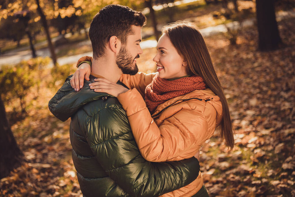 Photo of charming passionate couple guy hug his looking girlfriend in fall september town center park - Foto, immagini