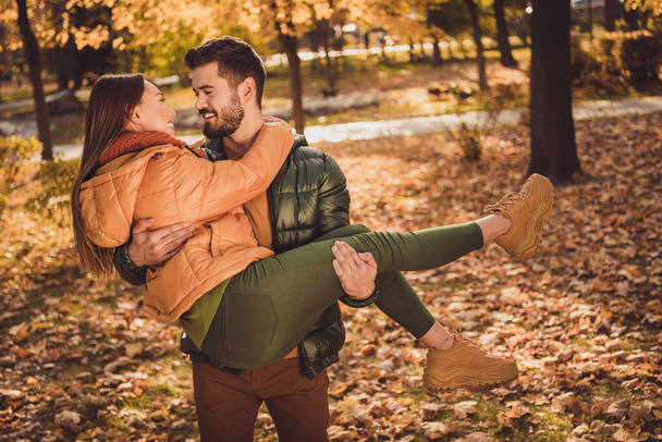 Photo of passionate bonding couple man hold hug his girlfriend in fall october forest park wear season coats - Foto, afbeelding