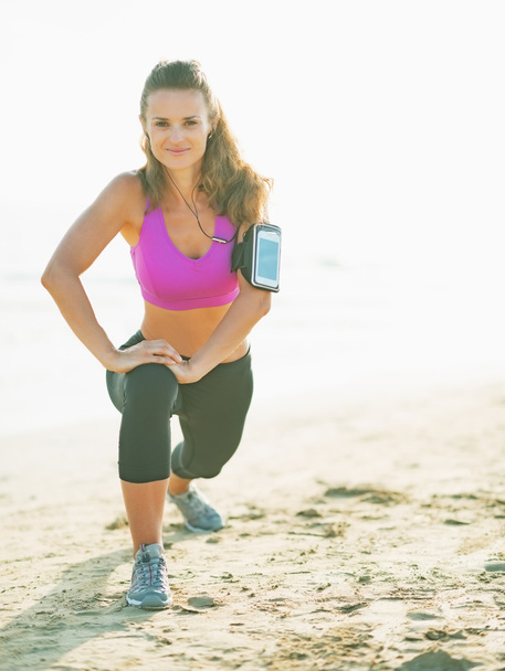 Fitness young woman making exercise on beach - Photo, image