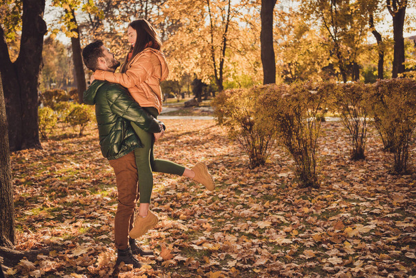 Profile side full size photo of bonding two people couple guy hold girlfriend in autumn september forest wear coats - Foto, afbeelding