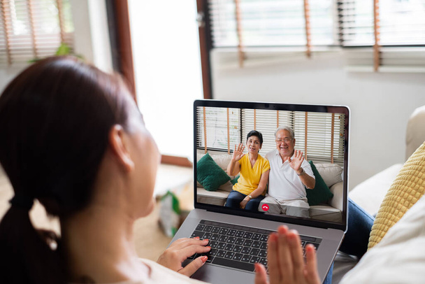 Aasialainen nainen tekee videopuhelun virtuaalinen tapaaminen perheen kanssa - Valokuva, kuva