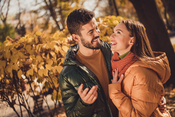 Photo of positive cheerful friends guy talk with pretty girl in autumn september outside town park woods - Foto, immagini