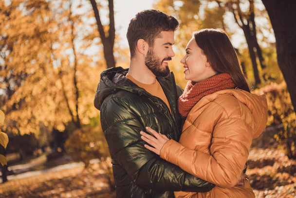Photo of bonding couple guy embrace cuddle his girlfriend in outside autumn town park wear season coat - Foto, afbeelding