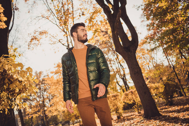 Low angle view photo of attractive positive guy go outdoors autumn park look wear season outercoat - Fotografie, Obrázek