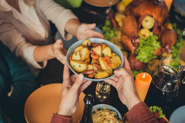 Cropped photo table arms share treat fried potato thanks giving dinner garnished turkey evening house living room indoors - Foto, Imagen