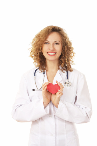 Female doctor with stethoscope holding heart - Foto, afbeelding