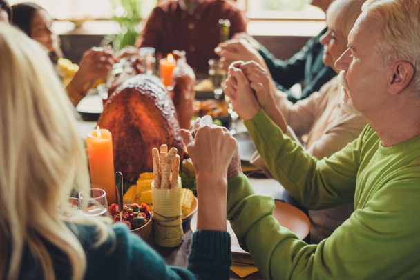 Full family grace prayer hold hands thanks giving tradition before dinner holiday sit served table turkey living room indoors - 写真・画像