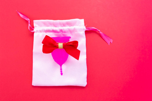 Menstrual cup as a gift, flat lay on pink background. Zero waste concept. Caring for the environment. Women Health. Picture with place for text - Photo, image