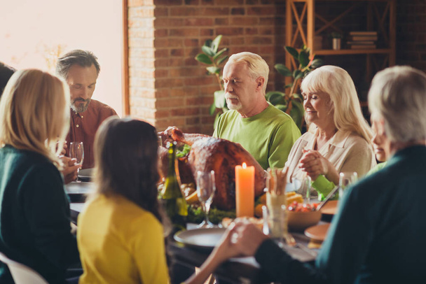 Photo of full family prayers hold hands thanks giving gathering sit table turkey autumn served dinner evening living room indoors - Photo, image
