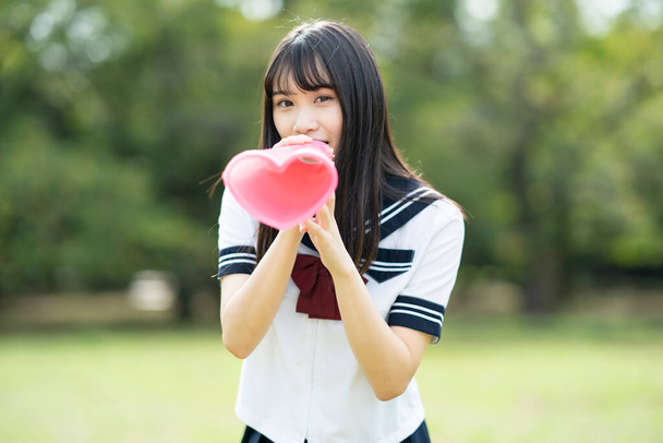 азіатська старшокласниця вітає з мегафоном у формі серця
 - Фото, зображення