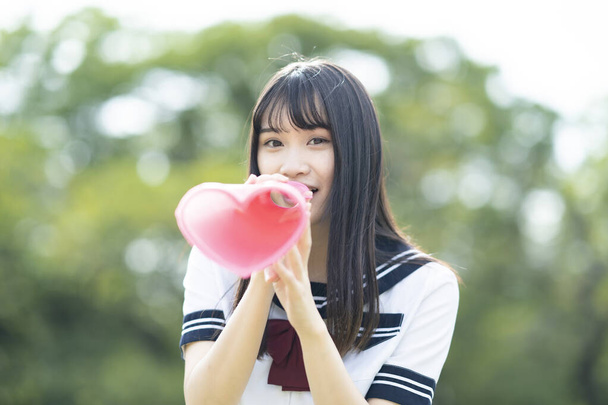 asiático High School secundaria chica animando con un corazón en forma de megáfono - Foto, Imagen