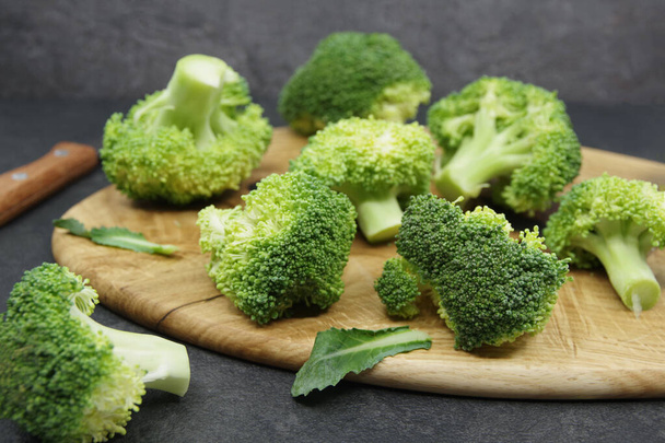 Tahta kesme tahtasında yeşil taze brokoli. Organik gıda hazırlığı. Sağlıklı yemek için sebzeler. Yakın çekim. - Fotoğraf, Görsel