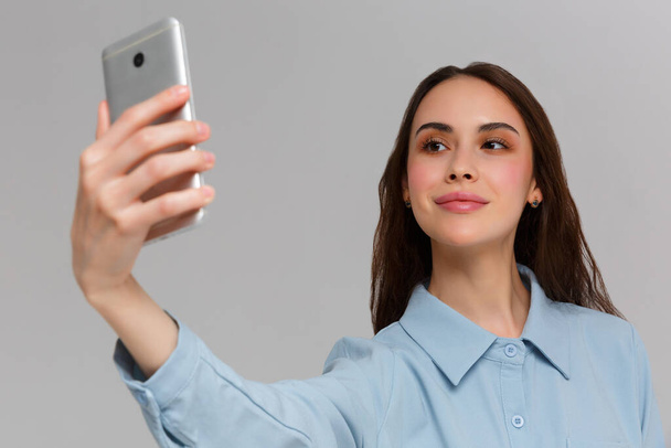 Krásná mladá žena dělá selfie foto s chytrým telefonem. - Fotografie, Obrázek