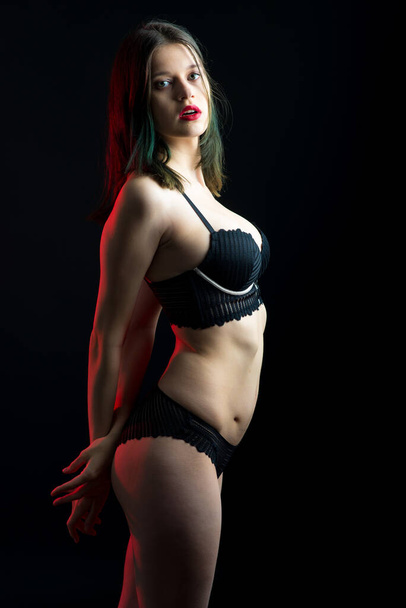 Vista vertical foto hermosa señora tímida en bikini de encaje bragas sujetador boudoir. Tierna forma delgada aislado fondo negro. - Foto, Imagen